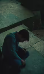 the man is sitting down looking at his phone