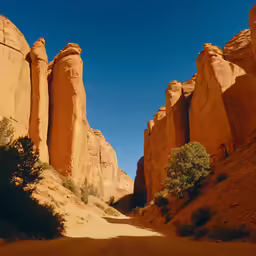 an arid road is passing by tall rocks