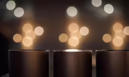 three black vases with white circles are on the table