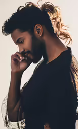 a person wearing a black shirt looking back with their hand in his chin