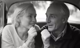 black and white photo of man and woman in car with spoons