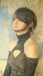 woman with short brown hair wearing a top, and choker, staring off to the side