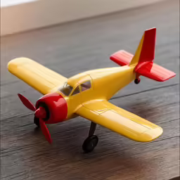 toy yellow airplane with red cockpit on wooden table