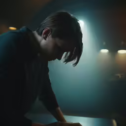 the woman is touching her laptop in the dark