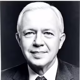 this photo shows a black and white portrait of a man wearing a suit, tie, and jacket