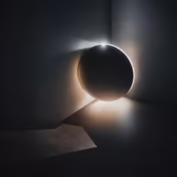 a round light fixture in a black room