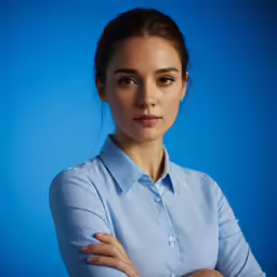 the woman poses in front of a blue background