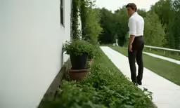 there is a man in suit and tie looking down the sidewalk