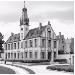a building with a clock tower is seen in black and white