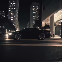 two black cars on the road next to tall buildings