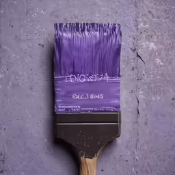 a wooden paint brush with purple paint on it