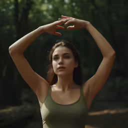 a woman in a green sports top holding her hands up to her head
