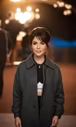 a woman with long black hair stands near lights