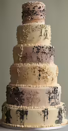 a white and brown three tier cake with lots of toppings