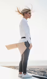 a woman standing on the ledge holding a purse