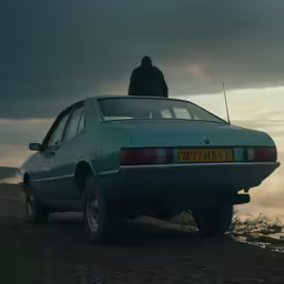 a man on top of a parked car