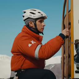 the young man is climbing up the mountain with his mountain bike