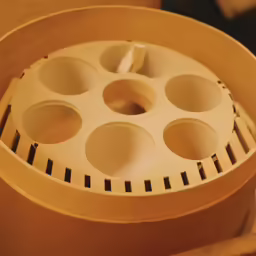a white plastic object with some holes inside
