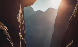 sunbeams are shining down on some steep mountains
