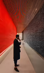 a person wearing a coat looking at a wall