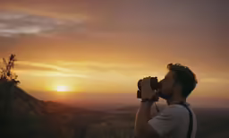 a man holding a camera looking into the sky