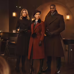 three women stand beside one man in a cafe