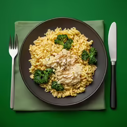 a plate filled with noodles and meat sauce on top of a napkin