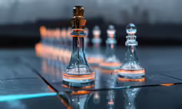 three chess pieces are displayed on a shiny surface