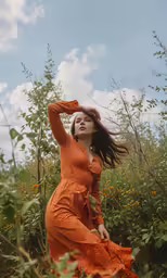 a woman standing in a field full of flowers and plants