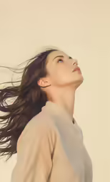 a woman with her hair blowing back in the wind