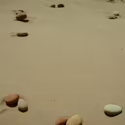 several rocks sticking out of the sand next to water