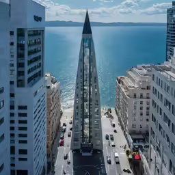 a view of a very tall building next to some other buildings near water