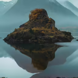 a mountain is shown on the shore of the lake