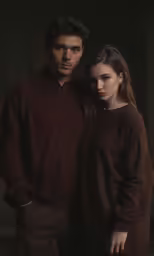 a man and woman pose for a photograph in a dark room