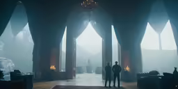 a couple of people standing in front of some very big windows