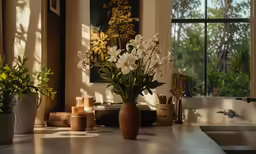 the flowers in vases are beside some flowers on the counter
