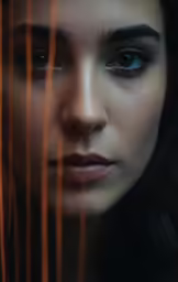 a woman with blue eyes looking over curtains