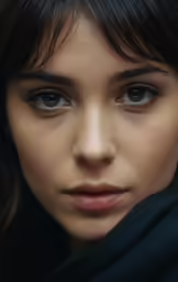 a woman with black hair and eyes has very large, dark eyes