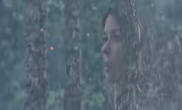 a woman looking out a window at the rain