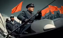 two soldiers on a boat in front of orange flags