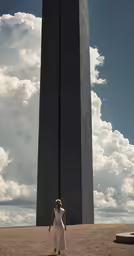 woman in white dress standing in front of two obelisk