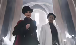 two ladies standing next to each other wearing white coats