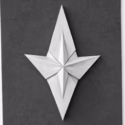 a folded white origami piece on a gray background