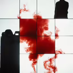 a man standing next to a red smoke bubble