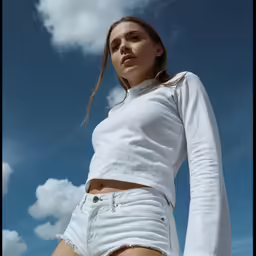 the woman is posing for a photo in denim shorts