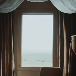 a large window in a bedroom with curtains over it
