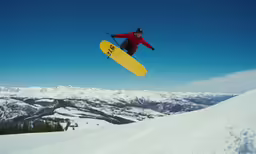 a snowboarder flies in the air after jumping