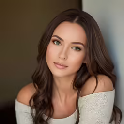 woman with brown hair and white top posing for picture
