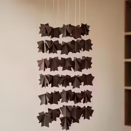 a display of dark colored paper origami hanging from strings