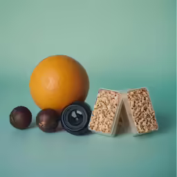 an orange next to a pair of plastic containers and a peanut shell